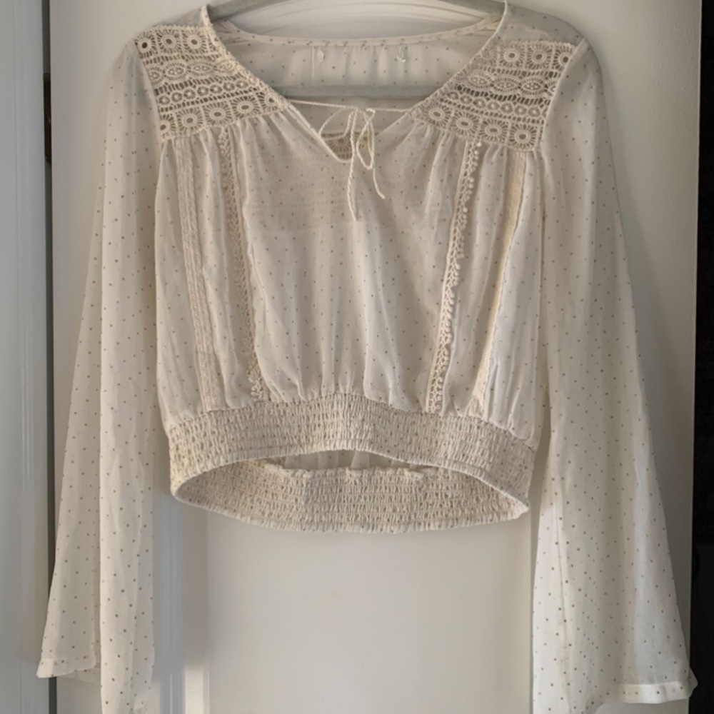 A cream top with lace and gold beading